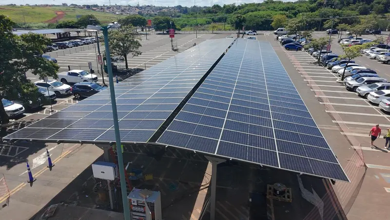 Fileira do carport solar coberta de painéis sobre as vagas do estacionamento, vista do alto