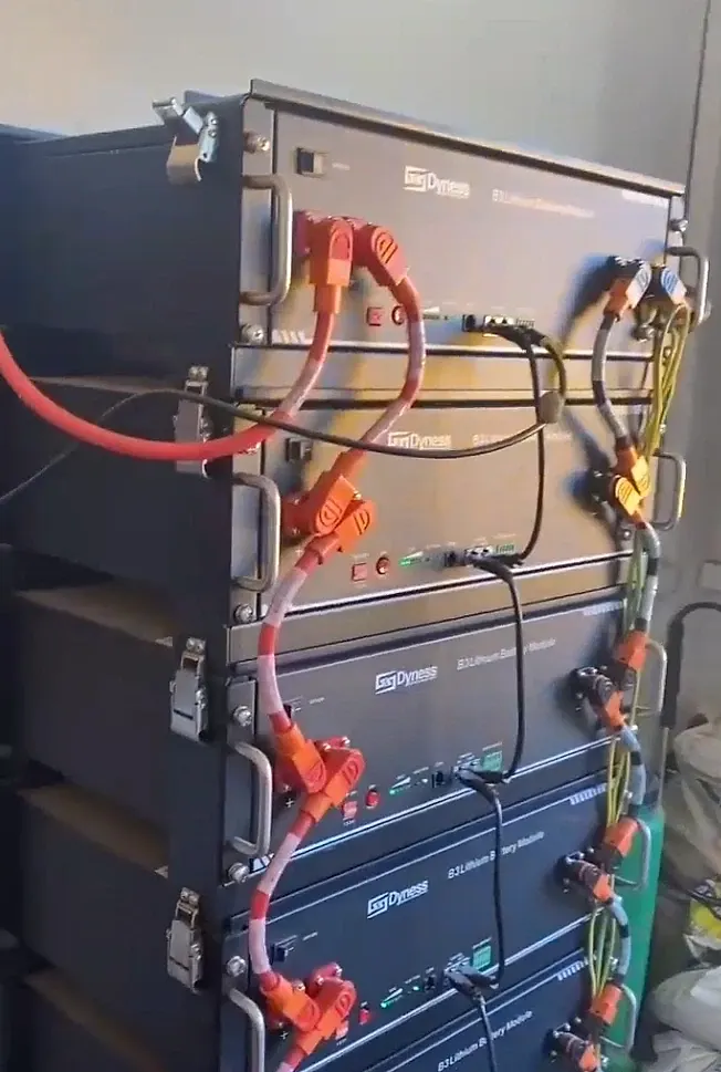 Banco de baterias de lítio empilhadas num rack, com os cabos de potência ligando um módulo ao outro